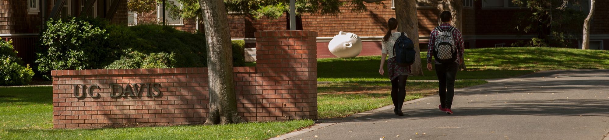 Students walking by UC Davis sign